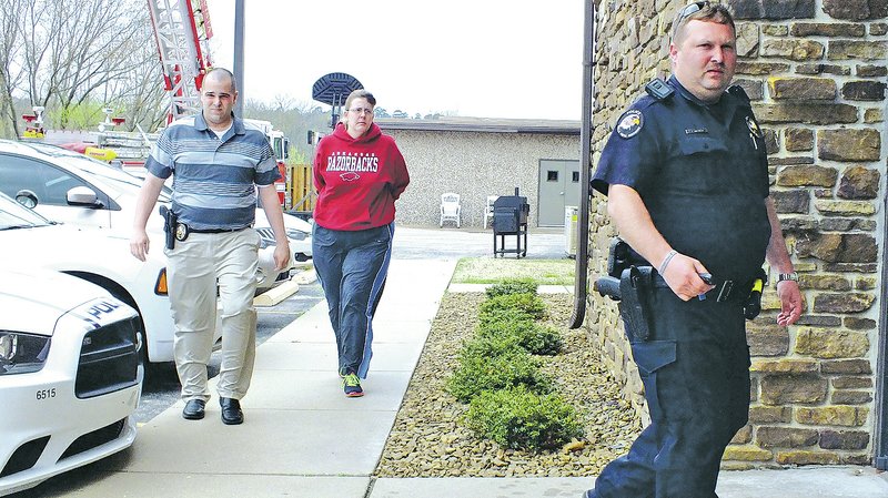 NWA Democrat-Gazette/BRANDON HOWARD Cathy Lynn Torres, 43, is brought into the Bella Vista Police Department on Monday by Sgt. Clayton Roberts (left) and Officer Terry Dickey. Torres was arrested in connection with capital murder, rape and battery in the first degree. She was arrested along with her husband Mauricio Alejandro Torres, 45, in connection with the death of a 6-year-old boy.