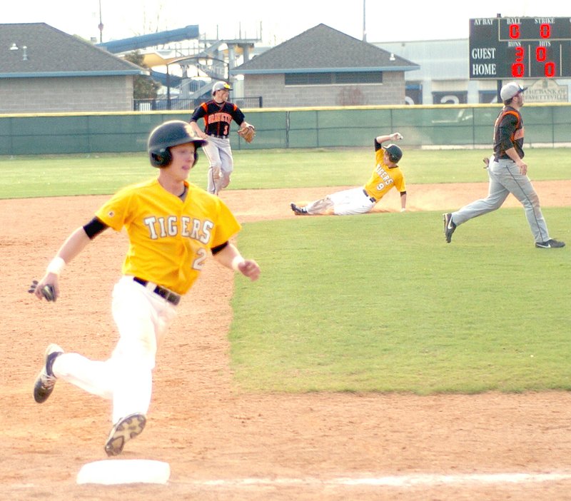 MARK HUMPHREY ENTERPRISE-LEADER Prairie Grove&#8217;s Gavin Heltemes races into third while Patrick Perdue slides into second advancing while Logan Gragg is out at first. Heltemes drew a walk and Perdue singled in the sixth inning. Both base runners went on to score on Reed Orr&#8217;s RBI double with the Tigers beating Gravette, 12-3, on Thursday.