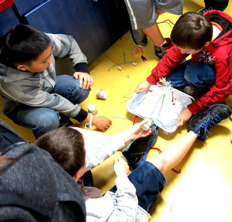 Photo by Mike Eckels Three members of the fourth- and fifth-grade classes of Decatur Northside Elementary School demonstrate their drawbridge design during the April 1 after-school program.