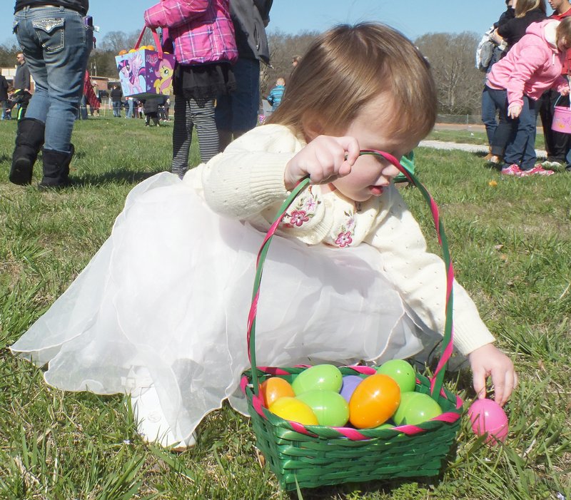 TIMES photographs by Annette Beard Aleah Munns, 2, picked up colored eggs at the Garfield Easter egg hunt Saturday. Aleah is the daughter of Codey and Katie Munns.