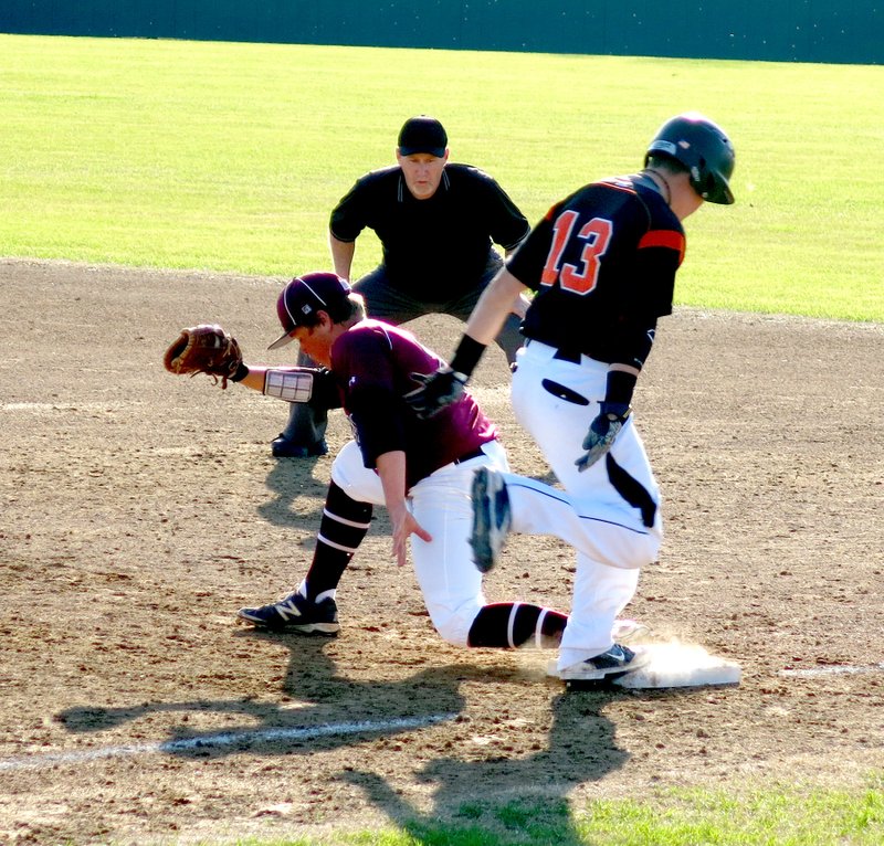 Photo by Mike Eckels Lincoln&#8217;s first baseman catches ball for the out a second before Bryce Moorman (Gravette #13) reaches the bag during the March 31 Lincoln-Gravette baseball game in Gravette. The Lions overwhelmed the Wolves, 11 to 1.