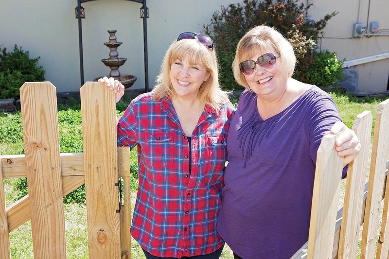 Cindy Romeo, left, and Liz Parker stand in the opening to the garden west of The Lantern Theatre, 1021 Van Ronkle St. in downtown Conway. Both are board members of the Conway Community Arts Association. An arbor, pictured in the background, was purchased in memory of Vic Quinn of Conway, who took care of the garden with his wife, Cathy. It will be dedicated April 17 as The Vic Quinn Memorial Garden during intermission of The Hammerstone. Donations for the garden may be sent to The Lantern Theatre, Conway Community Arts Association, P.O. Box 603, Conway, AR 72033. Those who donate at least $25 will get their names on a plaque that will be displayed in the theater’s lobby.