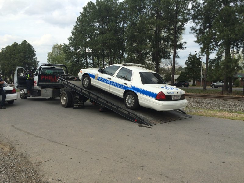A North Little Rock Police Department patrol unit is towed Wednesday, April 8, 2015, after department spokesman Sgt. Brian Dedrick said the car hit a department officer and a man the officer was pursuing near 700 W. 24th St. 