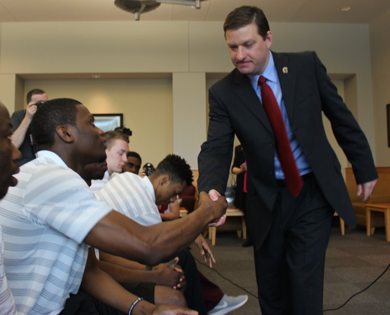 New UALR men's basketball coach Chris Beard shakes hands with junior guard Kemy Osse after an introductory news conference.