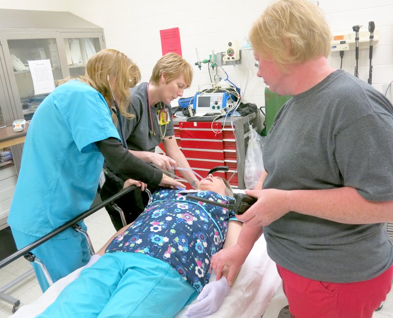 Dr. Marie Kane, Theresa Phelps and Angie King work with a patient in the emergency room at Ozarks Community Hospital during the disaster drill April 1. They check the person’s vital signs and record information used by the physician to decide where the patient will be sent and what treatment she will receive. OCH staff member Dayna Renfroe serves as the patient in the above photo.