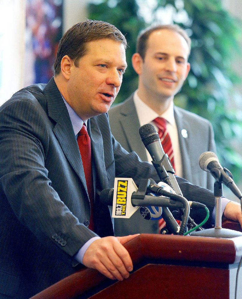 Chris Beard (left), flanked by UALR Athletic Director Chasse Conque, speaks Wednesday at a news conference where Beard was introduced as the Trojans’ men’s basketball coach. 