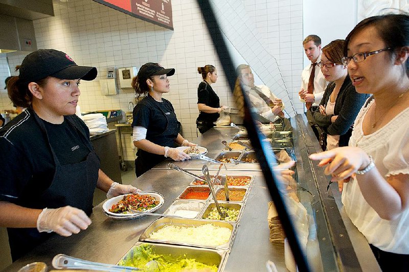 Chipotle Mexican Grill customers place orders at a restaurant in San Mateo, Calif., in this fi le photo. Chipotle is dealing with ingredient shortages because most of the nation’s fast-food suppliers can’t meet its food guidelines. 