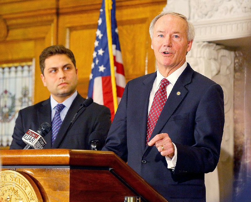 President Pro Tempore Jonathan Dismang, left, listens as Gov. Asa Hutchinson (right) calls for changes to House Bill 1228 at a news conference at the state Capitol in Little Rock in this file photo.