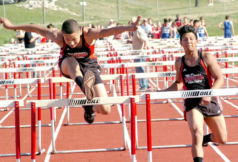 RICK PECK MCDONALD COUNTY PRESS McDonald County&#8217;s Chris Rubio leads teammate Francisco Gonzalez in the 110 meter hurdles at the 9/10 Mustang Stampede held March 30 at MCHS.
