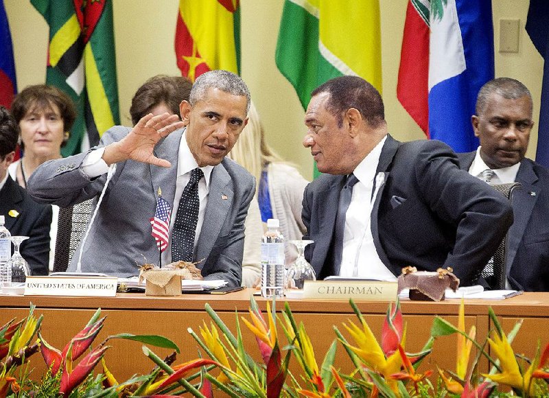 President Barack Obama talks with Prime Minister of Bahamas Perry G. Christie, right, at the summit with Caribbean Community (CARICOM) leaders, Thursday, April 9, 2015, in Kingston, Jamaica. The president said Thursday that he soon decide whether to remove Cuba from the U.S. list of state sponsors of terrorism now that the State Department has finished a review on the question as part of the move to reopen diplomatic relations with the island nation.(AP Photo/Pablo Martinez Monsivais)