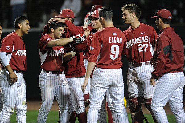 Andrew Benintendi (left) of Arkansas celebrates with teammates after hitting his second solo home run against Kentucky during the seventh inning Friday, April 10, 2015, at Baum Stadium in Fayetteville.