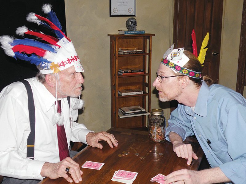 Victor, left, portrayed by Len Schlientz, and Murray, portrayed by Paul Browning, play Indian poker in a scene from The Hammerstone. Each of them takes a card and places it in his war bonnet. Each bets against the other’s cards. Instead of playing with poker chips, they play with coins.
