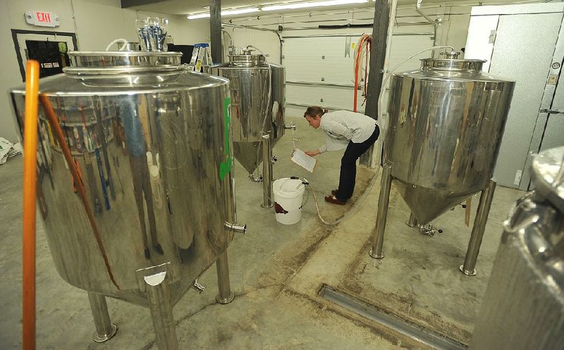 Carey Ashworth, co owner of Columbus House Brewery, checks on a batch of beer. In Arkansas, 16 breweries produced 10,591 barrels of beer in 2014, up from 2013 when 12 brewers produced 7,023 barrels of craft beer.