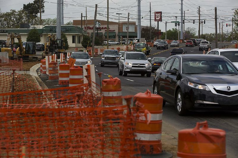 Cars pass construction along Cantrell Road near Mississippi Street and Tanglewood Shopping Center. Work to add a center turn lane is expected to be completed by spring 2016. 