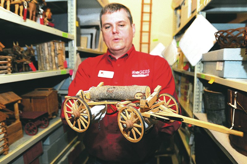 NWA Democrat-Gazette/J.T. WAMPLER John Burroughs, director of the Rogers Historical Museum, holds a turn-of-the-century toy pulled from an overcrowded shelf at the museum in downtown Rogers. The museum first opened in 1975 and it&#8217;s collection has outgrown its current location. For photo galleries, go to nwadg.com/photos.