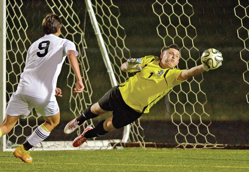 NWA Democrat-Gazette/BEN GOFF Fredy Mendez, Springdale Har-Ber goalkeeper, blocks Friday as Bentonville&#8217;s Zack Estrada charges the goal at the Tiger Athletic Complex in Bentonville.