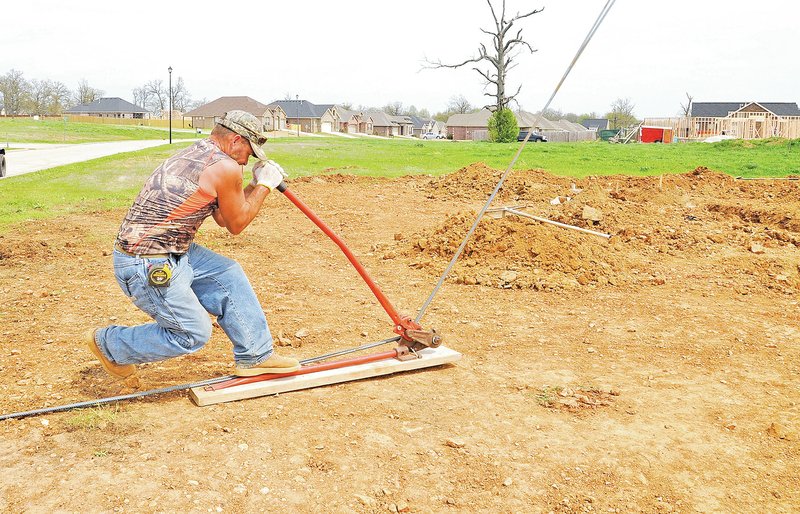 NWA Democrat-Gazette/J.T. WAMPLER Dewayne Richardson of Springdale bends steel rebar Wednesday while preparing a footer for a house under construction in the Brentwood development in Cave Springs. A recent study on the Cave Springs recharge area recommends new development standards in what it calls environmental vulnerability zones. The 19-square mile area is home to Ozark blink cavefish, listed as threatened on the federal Endangered Species List, and endangered gray bats. Cities will have to decide if they are going to adopt the new standards, but they will not apply to existing structures.