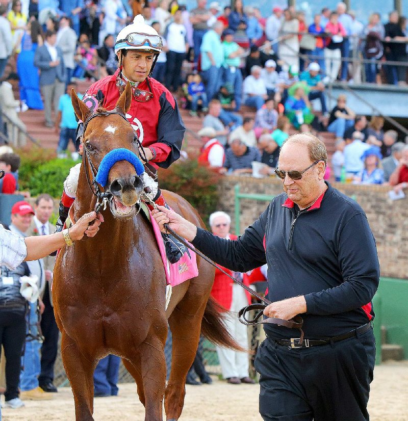 Frank Fletcher (right) leads his horse Wolf Man Rocket to the winner’s circle after he won the Northern Spur on Saturday at Oaklawn Park in Hot Springs. Wolf Man Rocket, ridden by Victor Espinoza, won the 1-mile race in 1:36.48. 