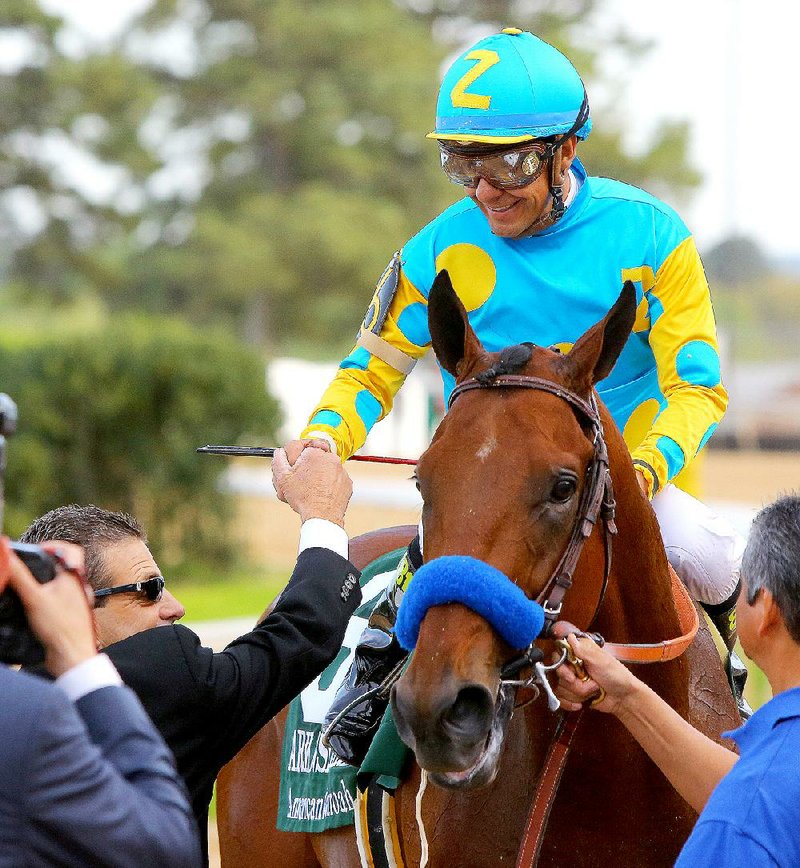 4/11/15
Arkansas Democrat-Gazette/STEPHEN B. THORNTON
Victor Espinoza aboard American Pharoah is congratulated by trainer Jimmy Barnes, bottom left,  after winning Saturday's Arkansas Derby at Oaklawn Park  in Hot Springs.