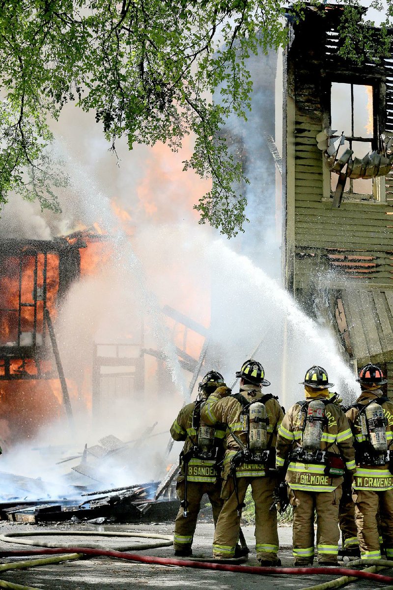 Little Rock firefighters battle a blaze Saturday at a vacant historic home at 908 Scott St. in Little Rock. The multistory wooden building was destroyed, and houses on both sides of it were damaged. 