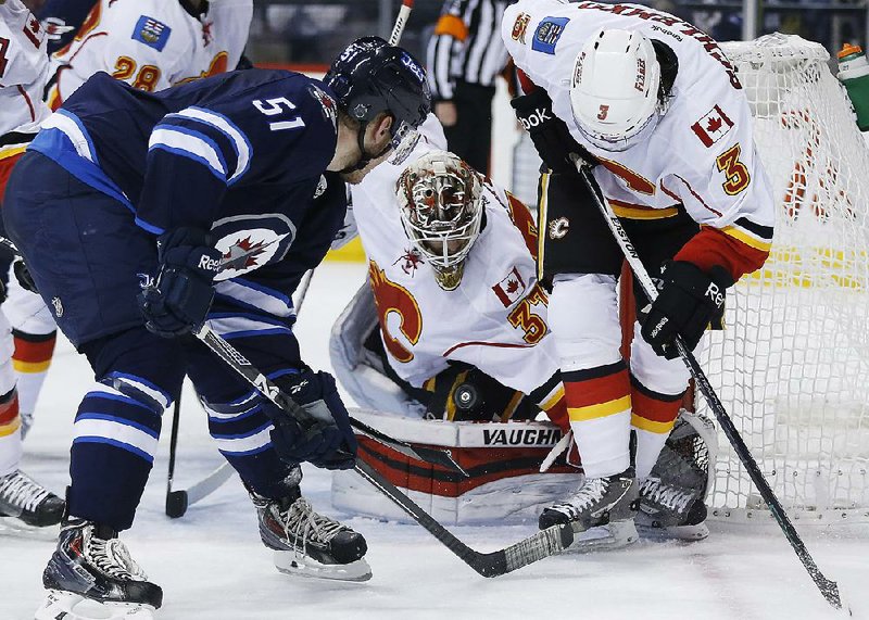 Calgary goaltender Joni Ortio (37) keeps his eye on the rebound against Winnipeg during a game Sunday in Winnipeg. The Flames blocked an average of 19 shots a game, which led the NHL.