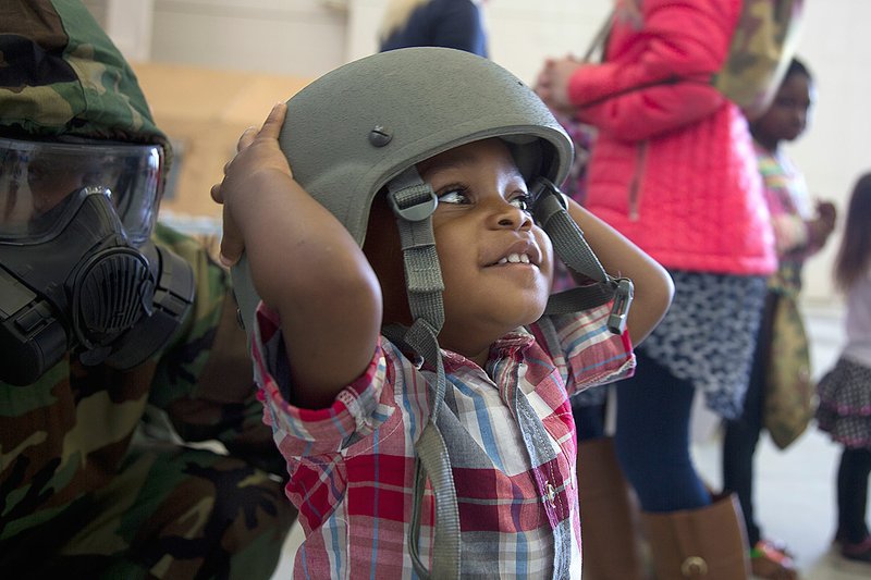 Mike Richardson Jr. tries on a helmet at the K.U.D.O.S. — Kids Understanding Deployment Operations — event at the Little Rock Air Force Base on Saturday. The activities at the base are provided for children of airmen to help them understand what happens when a parent in deployed.