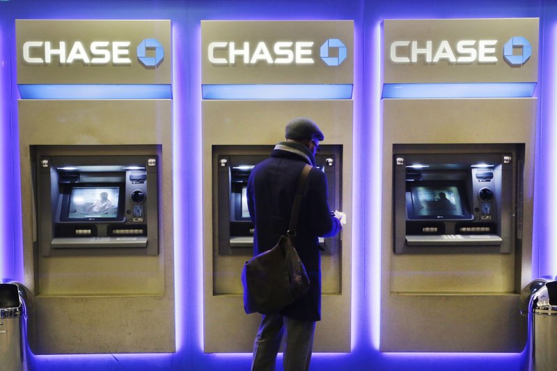 In this Jan. 14, 2015, photo, a customer uses an ATM at a branch of Chase Bank in New York. JPMorgan reports quarterly financial results on Tuesday, April 14, 2015.