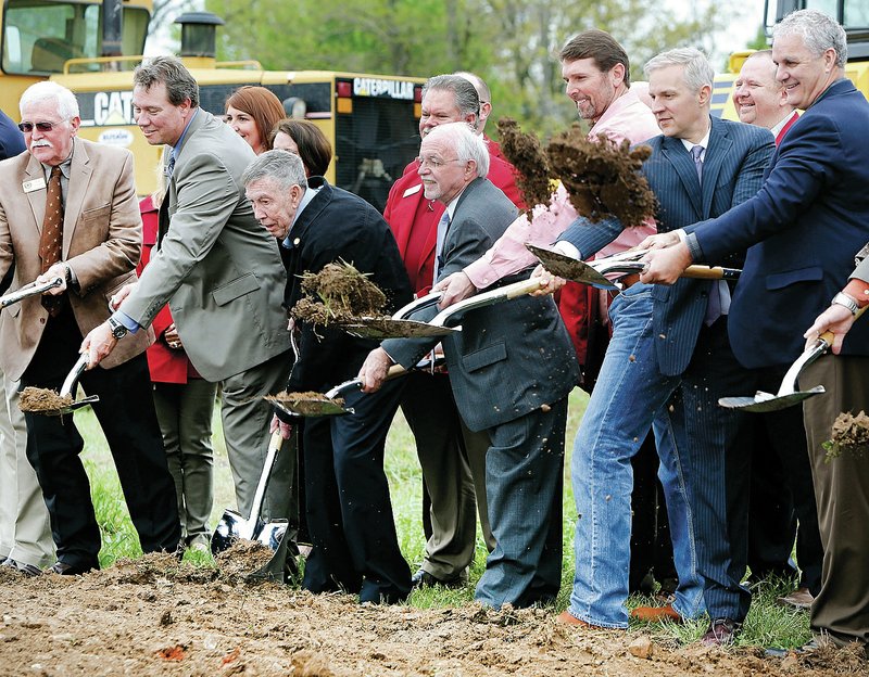 NWA Democrat-Gazette/DAVID GOTTSCHALK State and Northwest Arkansas officials and guests lift shovels of dirt during a groundbreaking Wednesday at the site of the new U.S. 412 Bypass in Lowell. The project is part of a new east-west route north of Springdale with a projected cost of $100,620,381 and estimated completion date in 2019.