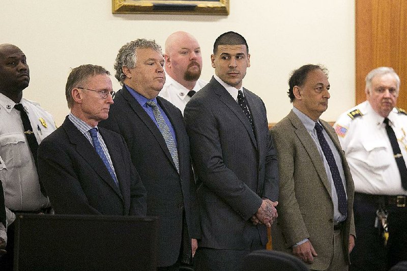 Former New England Patriots NFL football player Aaron Hernandez, center, stands with his defense attorneys, from left, Charles Rankin, Micheal Fee and James Sultan, as the verdict is read in his murder trial, Wednesday, April 15, 2015, at Bristol County Superior Court in Fall River, Mass. Hernandez was found guilty of first-degree murder in the shooting death of Odin Lloyd in June 2013. 