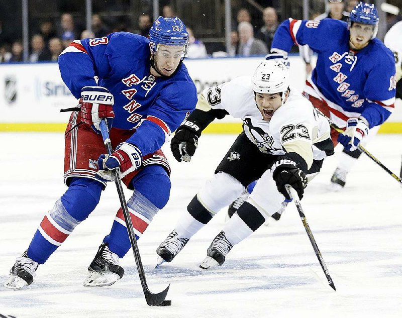 Pittsburgh Penguins' Steve Downie (23) fights for control of the puck with New York Rangers' Kevin Hayes (13) during the second period of Game 1 in the first round of the NHL hockey Stanley Cup playoffs Thursday, April 16, 2015, in New York.  (AP Photo/Frank Franklin II)