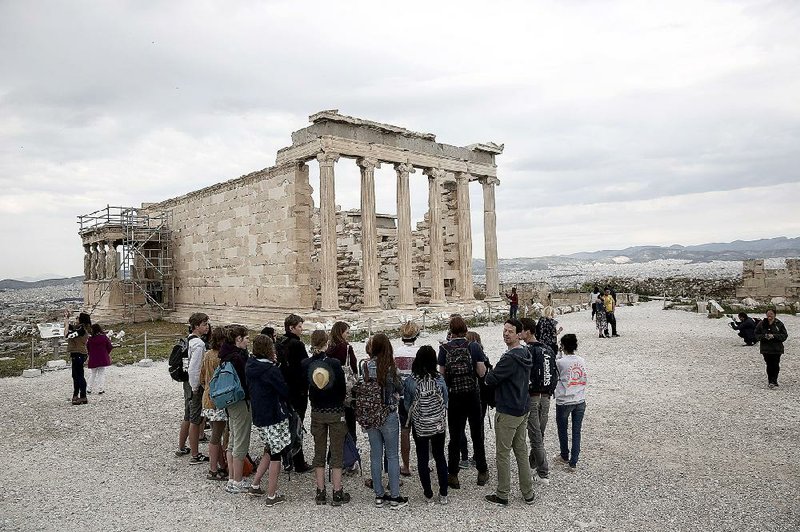 Tourists listen to a guide near the Erechtheion temple at the Acropolis in Athens on Wednesday. The nation’s borrowing costs surged Thursday on worry about the potential for a Greek debt default. 