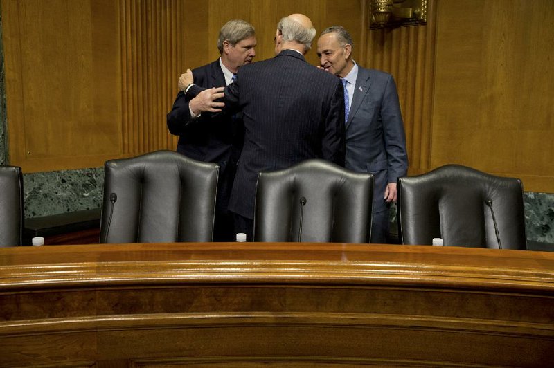 Agriculture Secretary Tom Vilsack (from left) speaks with Sen. Pat Roberts, R-Kan., and Sen. Charles Schumer, D-N.Y., before the start of a Senate Finance Committee hearing Thursday on the “fast track” trade bill.