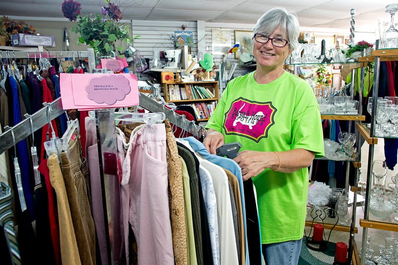 Bev Finch prices clothing at the Bargain Hound Boutique in Batesville. The thrift store supports the Independence County Humane Society.