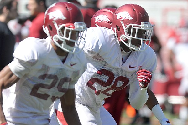 Arkansas defensive backs Jared Collins (29) and Josh Liddell (28) go through practice Saturday, April 11, 2015, at Donald W. Reynolds Razorback Stadium in Fayetteville. 