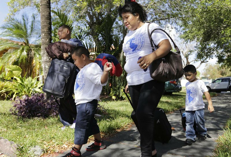 Victor Pablo, 6, second from left, carries a stuffed toy as he walks with Angelika Perez and Christopher Pablo, three, right, to board a van leaving in a caravan to New Orleans, Thursday, April 16, 2015, in Miami. Hundreds of immigration reform supporters and activists are expected to be outside of the Fifth Circuit Court of Appeals in New Orleans Friday. A panel of three judges will weigh a request by the Department of Justice which would allow recent executive orders on immigration to proceed, which could stop the deportation of about 5 million immigrants. 