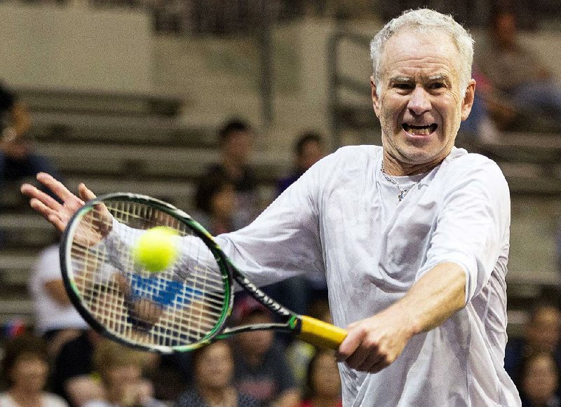 John McEnroe backhands a shot from Andy Roddick on Friday night during the final of the Champions Cup in front of 2,879 at the Jack Stephens Center on the UALR campus. McEnroe, a seven-time Grand Slam winner, lost 6-3 to Roddick.