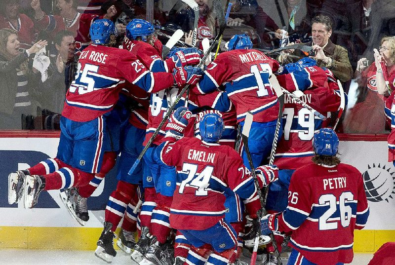 Members of the Montreal Canadiens pile on teammate Alex Galchenyuk following his winning goal in overtime Friday night against the Ottawa Senators. Montreal won 3-2 to take a 2-0 series lead. 