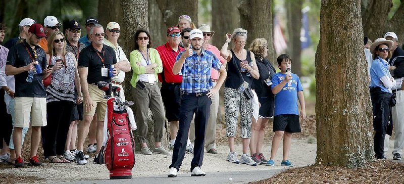 PGA Tour golfer Troy Merritt gives thumbs-up to a marshal after clearing a path to hit from the cart path on the 15th fairway during the second round of the RBC Heritage tournament in Hilton Head Island, S.C., on Friday. Merritt hit around a tree and finished with a 61 to tie the course record and take a four shot lead into today’s third round.