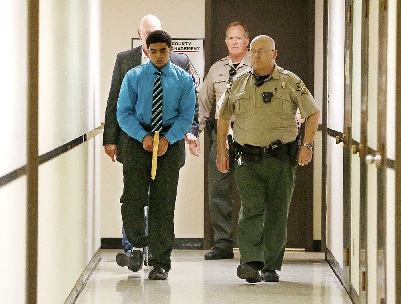 Chancey Luna is led from the courtroom in shackles and handcuffs after being convicted Friday in Duncan, Okla., in the death of Australian baseball player Christopher Lane. 