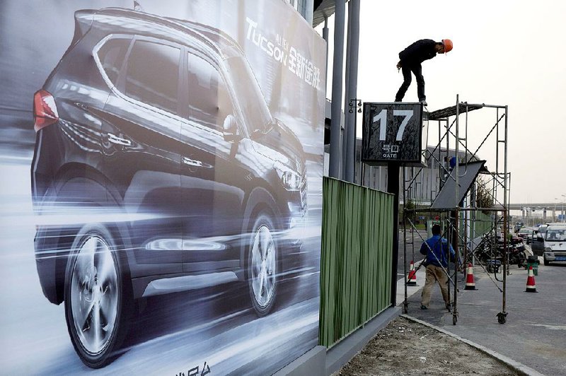 A worker prepares a sign Thursday for the annual auto show in Shanghai, the biggest marketing showcase of the year for Chinese brands. 