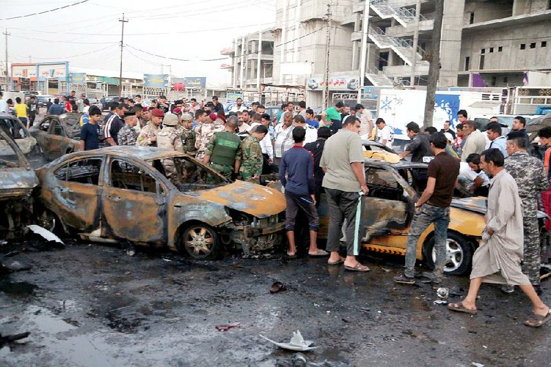 Iraqis gather after a car bomb was set off Friday in the Habibya neighborhood in Baghdad. 