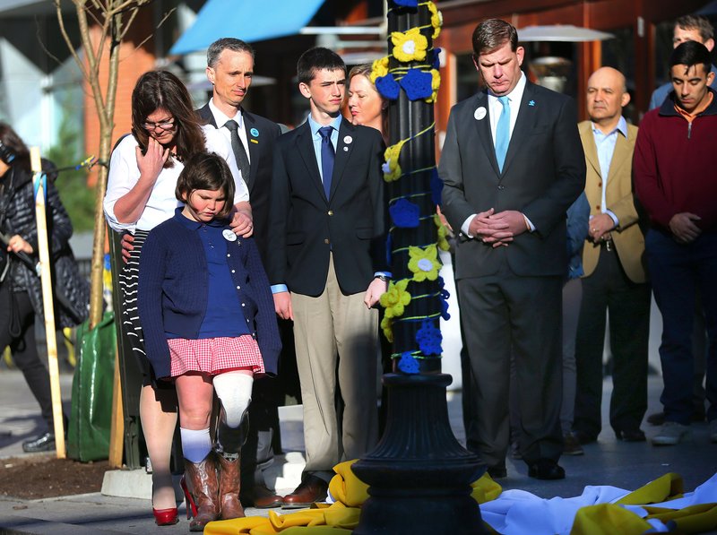 Boston Mayor Marty Walsh, right. looks down after Boston Marathon survivor Jane Richard, left, and her brother Henry removed a drape covering a memorial honoring victims and survivors at one of two blast sites near the finish line of the Boston Marathon in Boston, Wednesday, April 15, 2015.  Parents, Bill and Denise Richards, back,  stood by during the unveiling.  