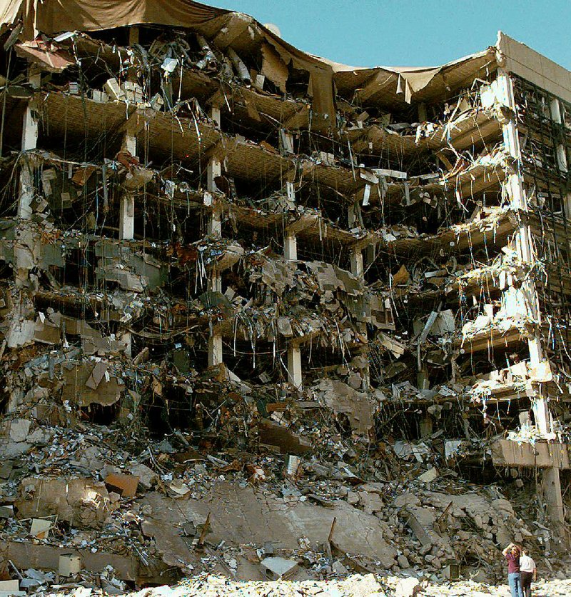 Rescuers stand in front of the rubble of the Alfred P. Murrah Federal Building in Oklahoma City on April 19, 1995, after Timothy McVeigh detonated a truck bomb that killed 168 people and injured another 684. 