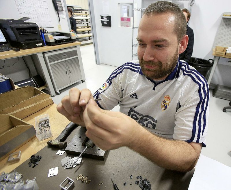 Aaron Causey assembles an aerospace latch Friday at Galley Support Innovations in Sherwood. The business markets its hardware around the world, and countries’ differing rules on imports can slow deals and shipments, a company official says. 