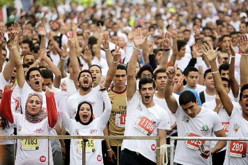 Runners loosen up Friday before the start of the annual half-marathon race in the Heliopolis district of Cairo. 