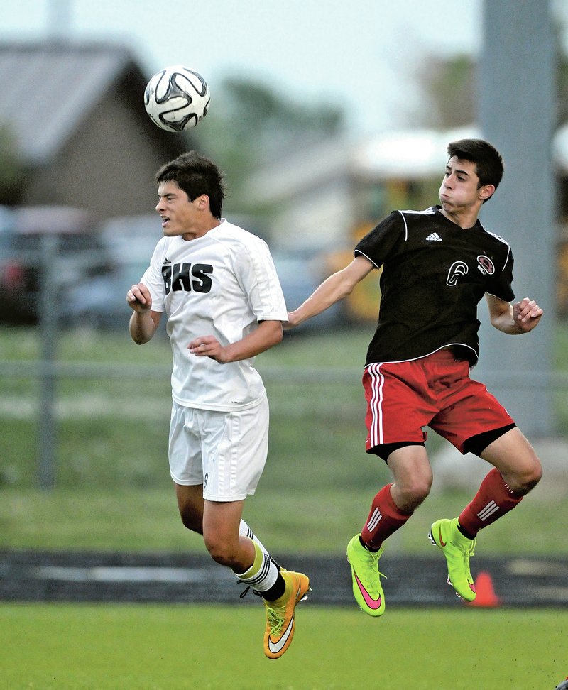 NWA Democrat-Gazette/BEN GOFF Zack Estrada (left) of Bentonville wins a header Friday over Pablo Cortes at the Tiger Athletic Complex in Bentonville.