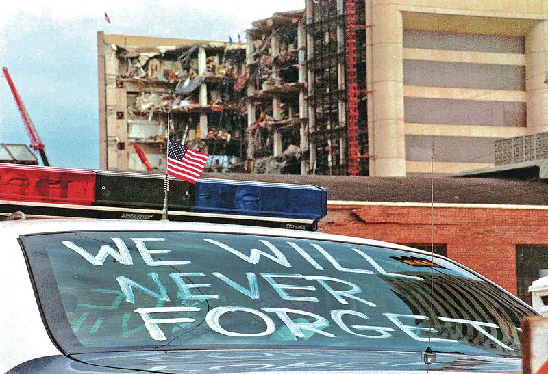 An Oklahoma City police car decorated with the words, “We will never forget,” and a small American flag sits near the Alfred P. Murrah Federal Building on April 24, 1995. The blast killed 168 people, including 19 children, injured hundreds more and caused hundreds of millions of dollars in damage to structures and vehicles in the downtown area. Today is the 20th anniversary of the bombing of the building.