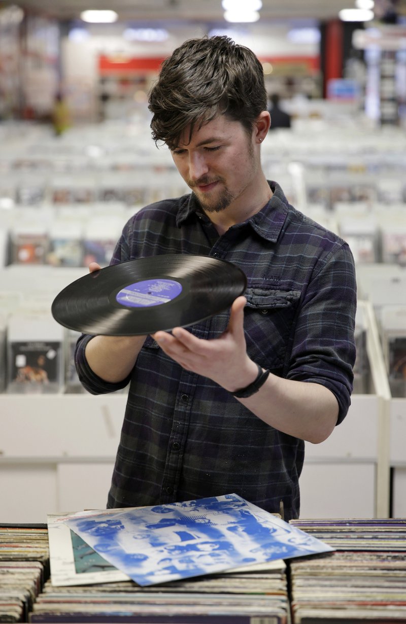 Record clerk Josh Kelly checks the condition of a used LP record
as he puts it in a sales bin at Vintage Vinyl Records last week
in Fords, N.J. A recent Rutgers graduate, Kelly is working at the
record store and living with friends while he tries to land a job in
journalism or radio programming.