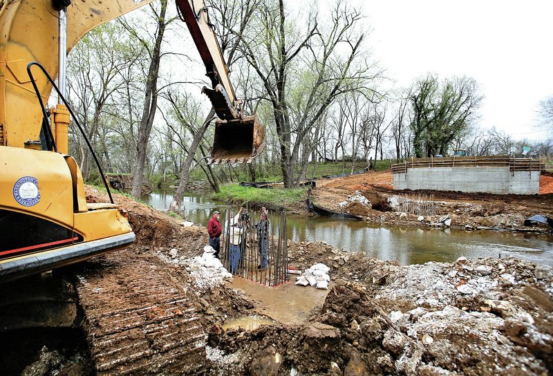 File Photo/NWA Democrat-Gazette/DAVID GOTTSCHALK Washington County officials and personnel from GTS Inc. of Fayetteville do a hydraulic pressure test on April 2 on rebar attached to the footings of piers for the Stonewall Bridge on Stonewall Road in Washington County.