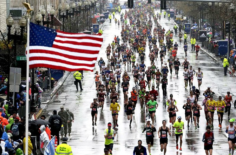 Runners approach the finish line in the rain during the Boston Marathon, Monday, April 20, 2015, in Boston. (AP Photo/Charles Krupa)